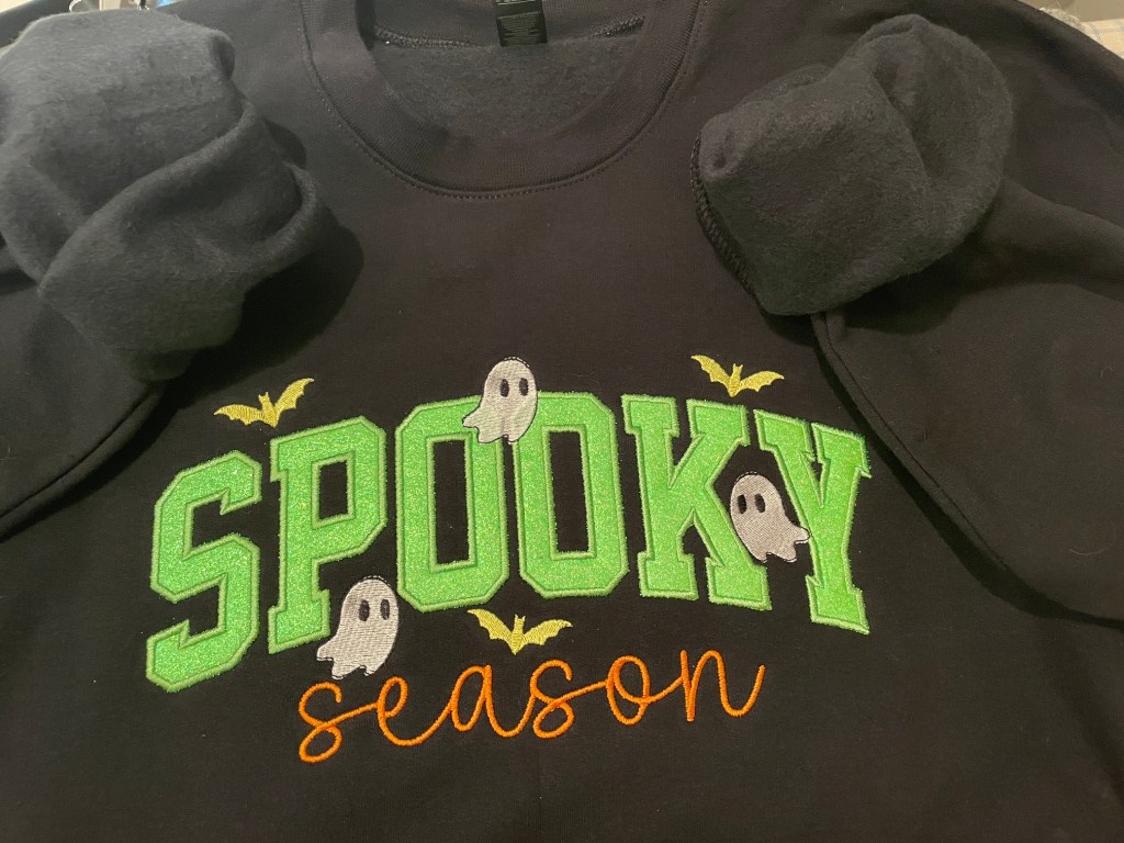 Image of black crew sweatshirt with Spooky embroidered on the front